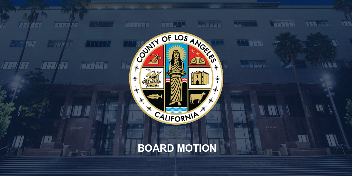 County of Los Angeles seal over a government building at night with palm trees and steps
